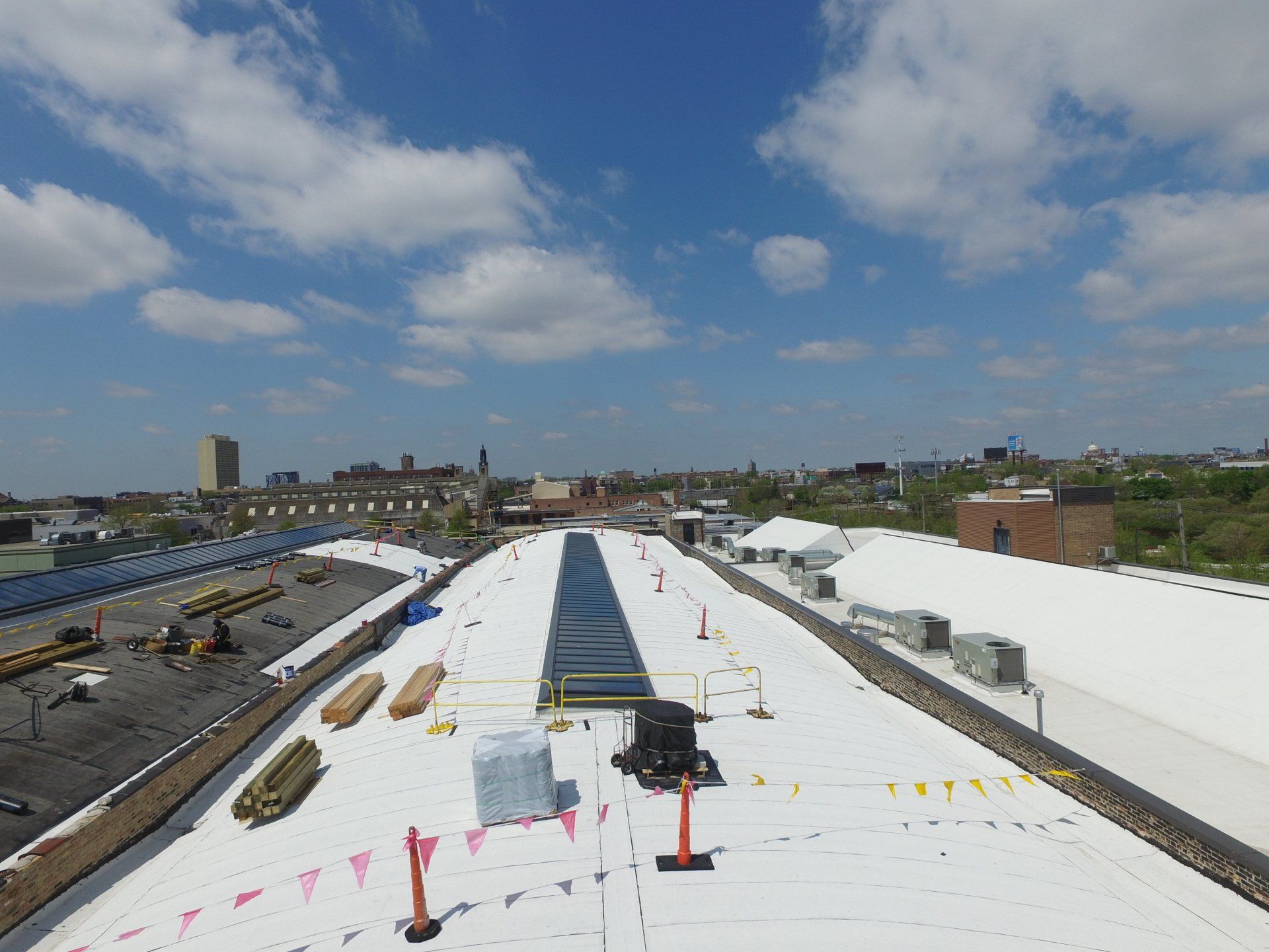 An aerial view of a large white roof with a city in the background.