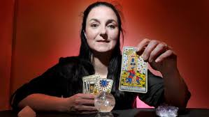 Sarah Kulkens Sarah Kulkens holding a tarot card and a crystal ball.