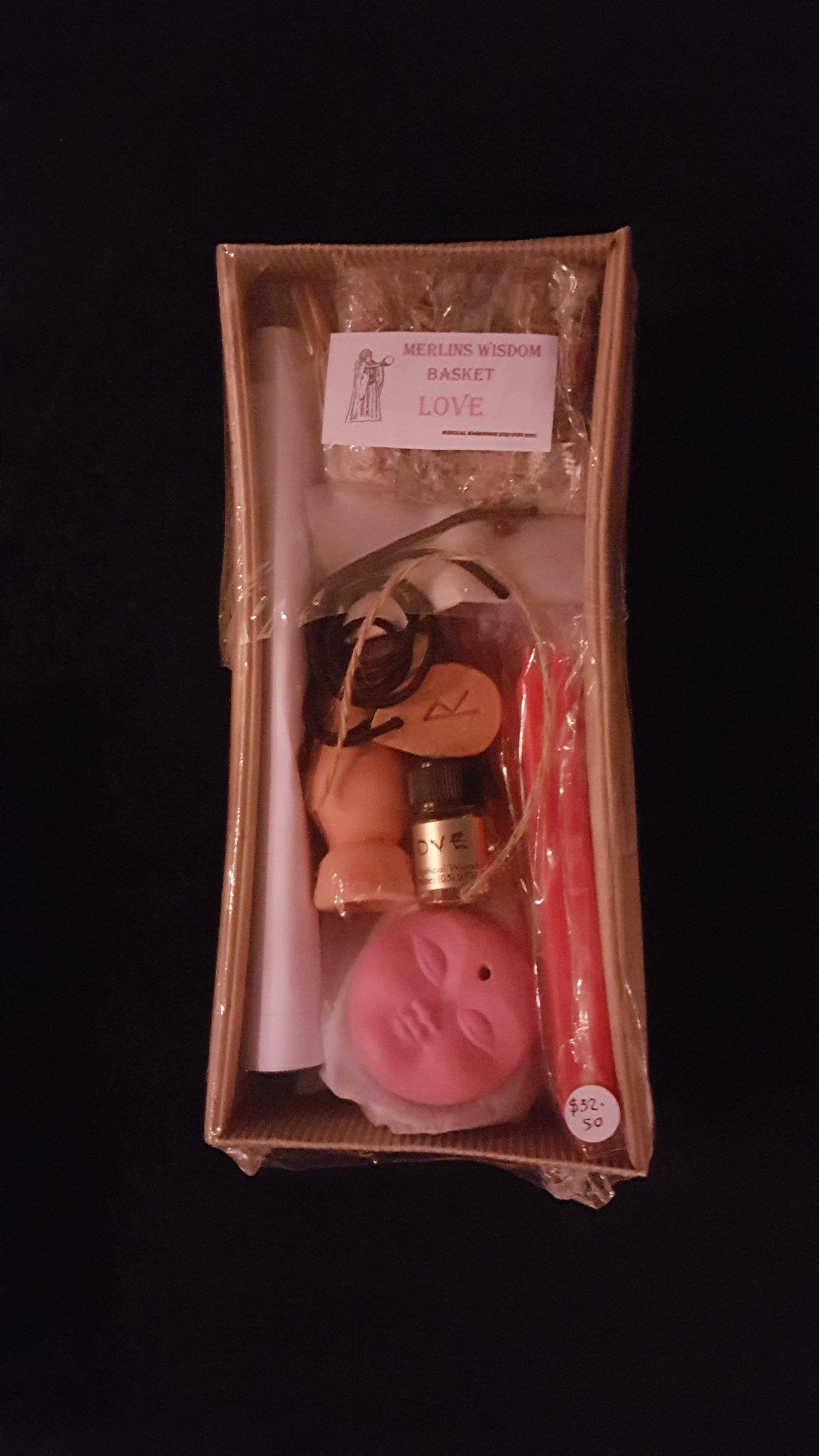 A box filled with candles , soap , and a bottle of oil.