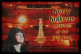 Kerry Kulkens A woman is standing in front of a chandelier in a theater.