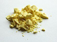 A pile of yellow powder on a white surface.