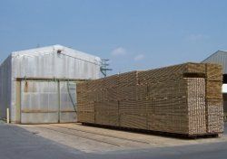 Treated Lumber — Man Paints a Wooden with a Wooden Brush for Protection Against Corrosion in the Garage in Oaklyn, NJ Treated Lumber — Man Paints a Wooden with a Wooden Brush for Protection Against Corrosion in the Garage in Oaklyn, NJ