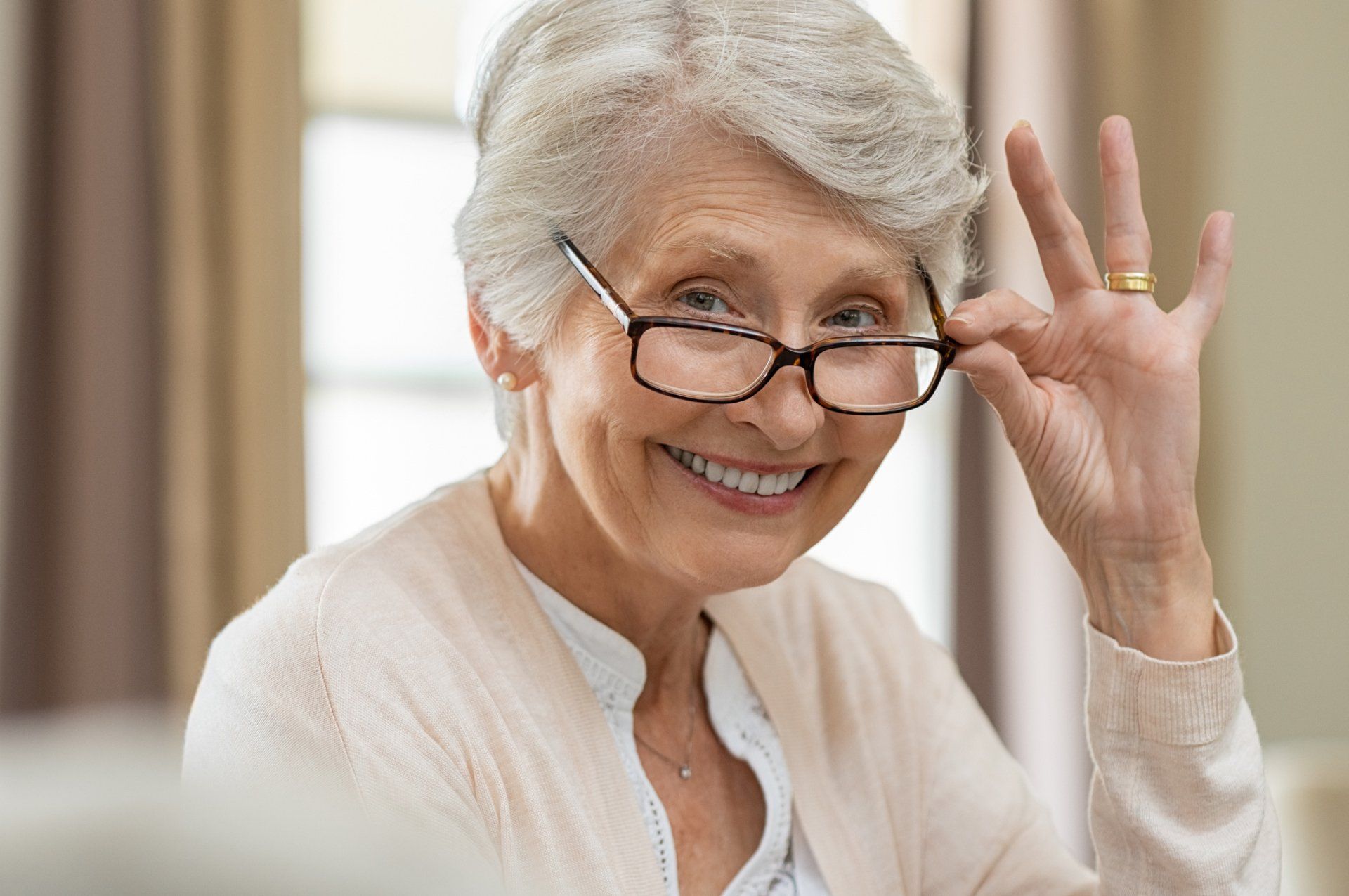 Glasses — Senior woman holding eyeglasses in Highland, IN Glasses — Senior woman holding eyeglasses in Highland, IN