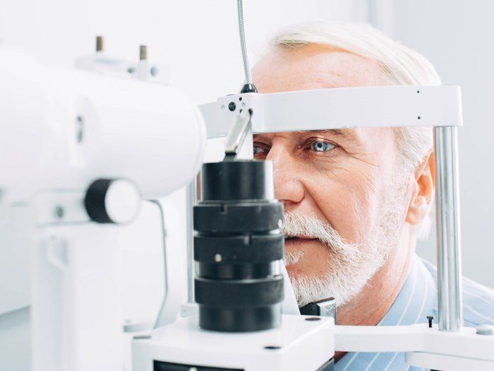 Optometrist — Senior man getting eye exam in Highland, IN Optometrist — Senior man getting eye exam in Highland, IN
