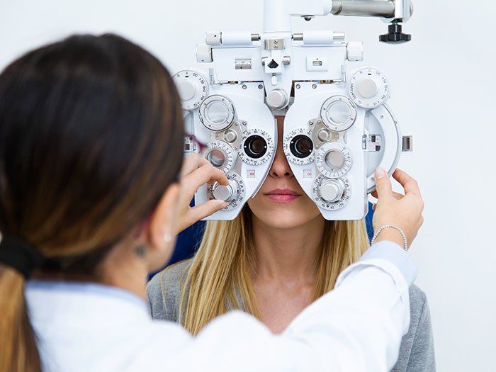 Vision Testing — Young Woman Sitting with the Optician in Highland, IN Vision Testing — Young Woman Sitting with the Optician in Highland, IN