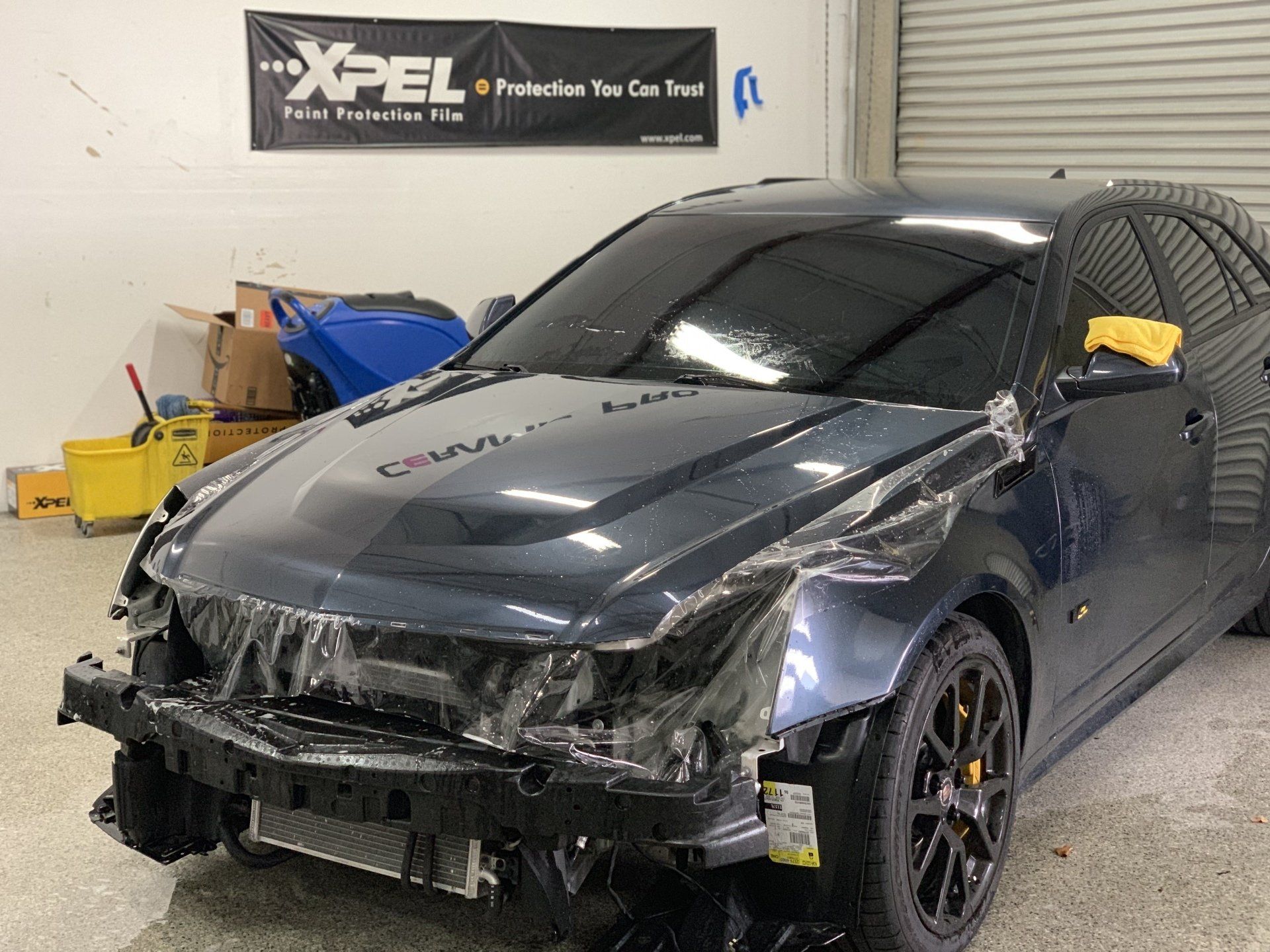 A car is wrapped in plastic in a garage.
