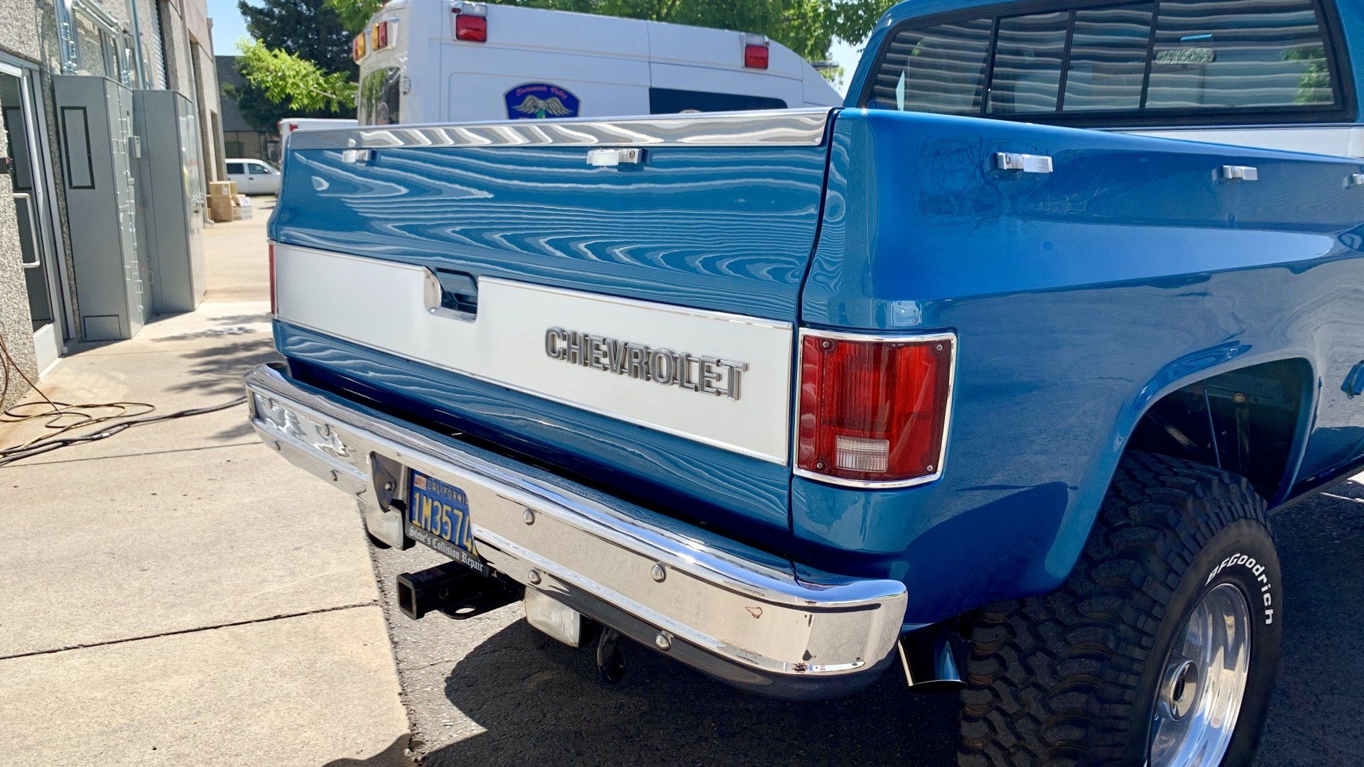 A blue chevrolet truck is parked on the side of the road.