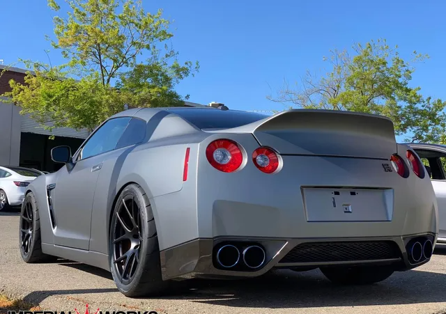 A gray nissan gtr is parked in a parking lot