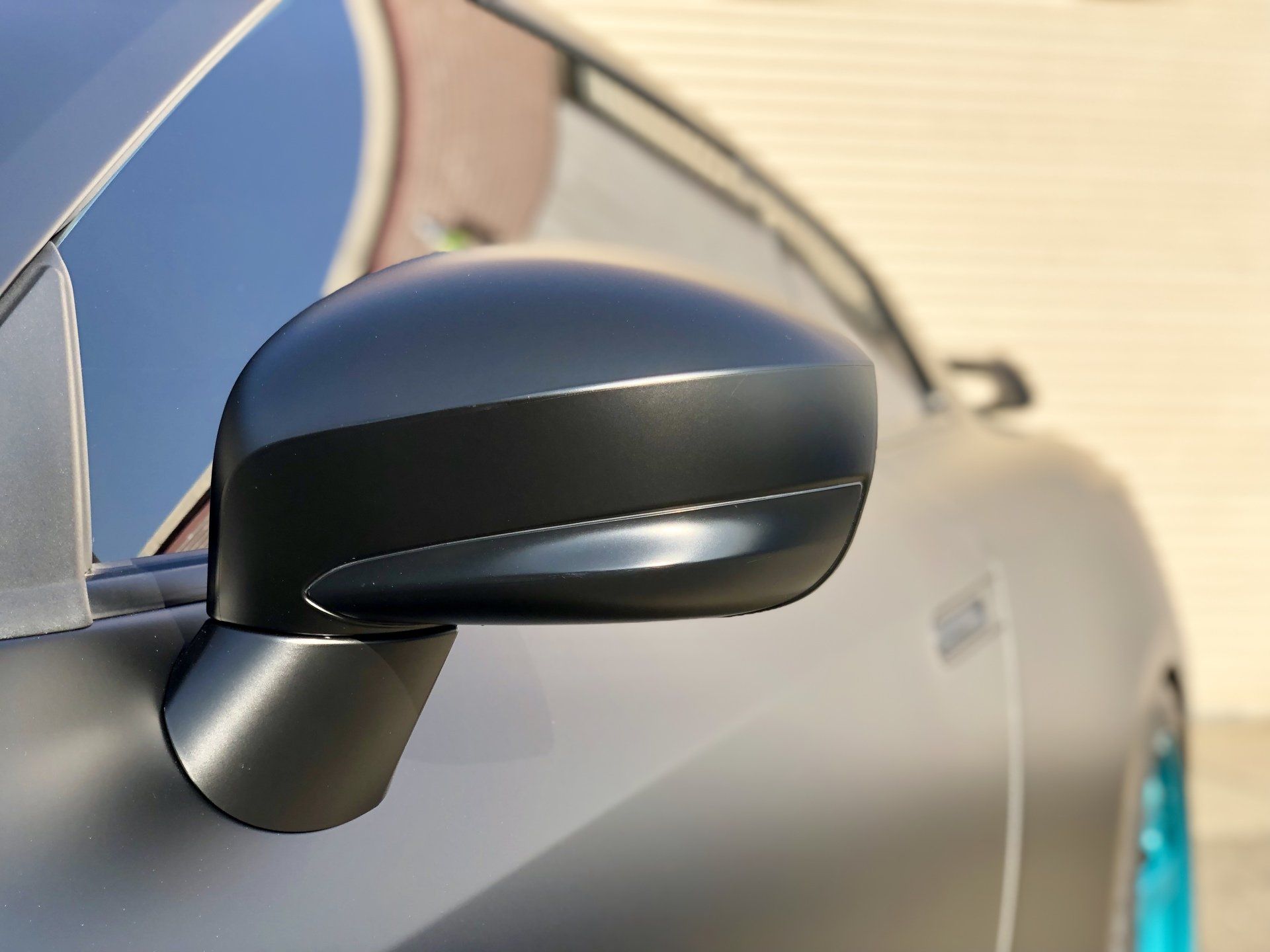 A close up of a black car 's side mirror