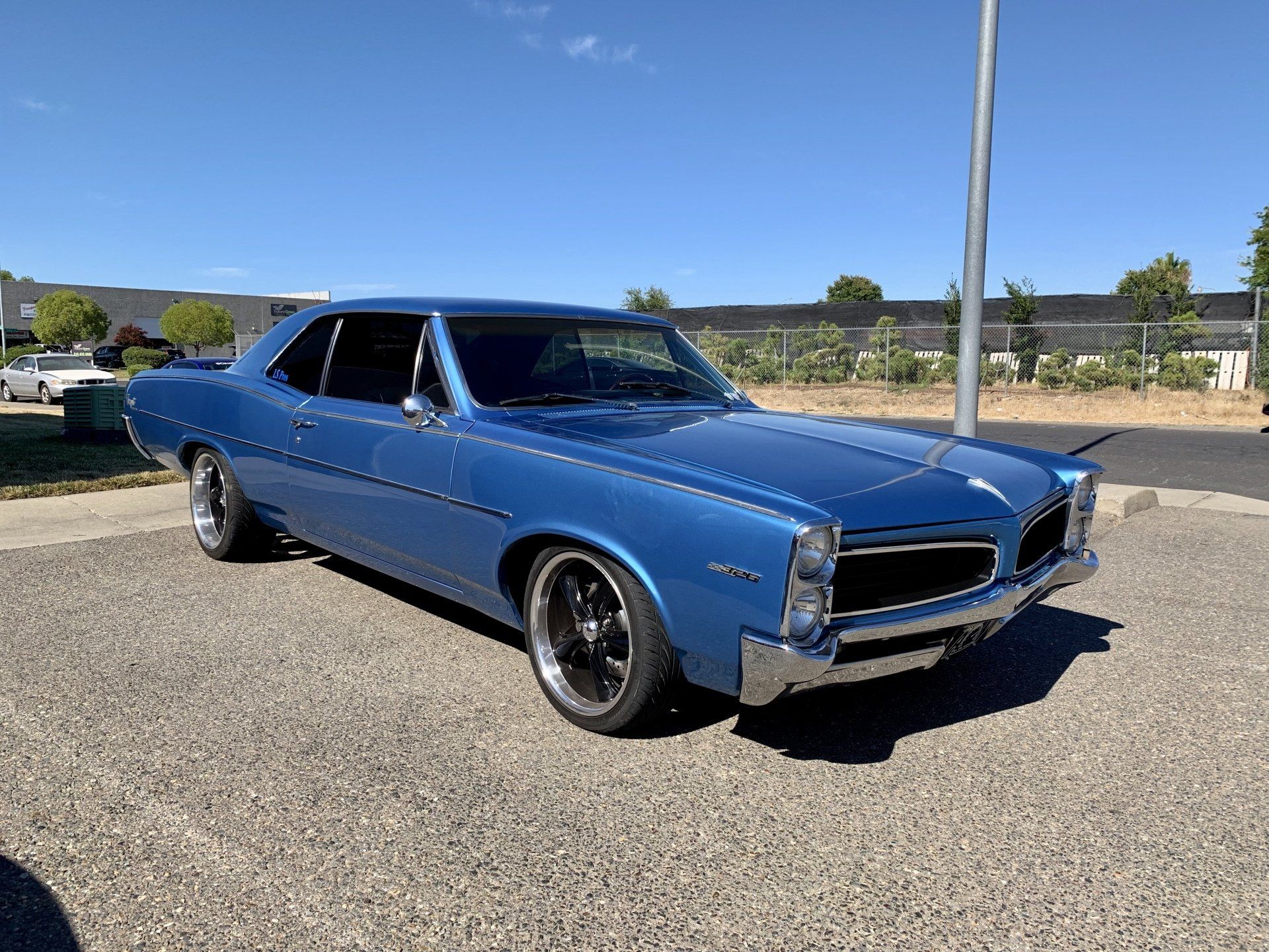 A blue car is parked on the side of the road.