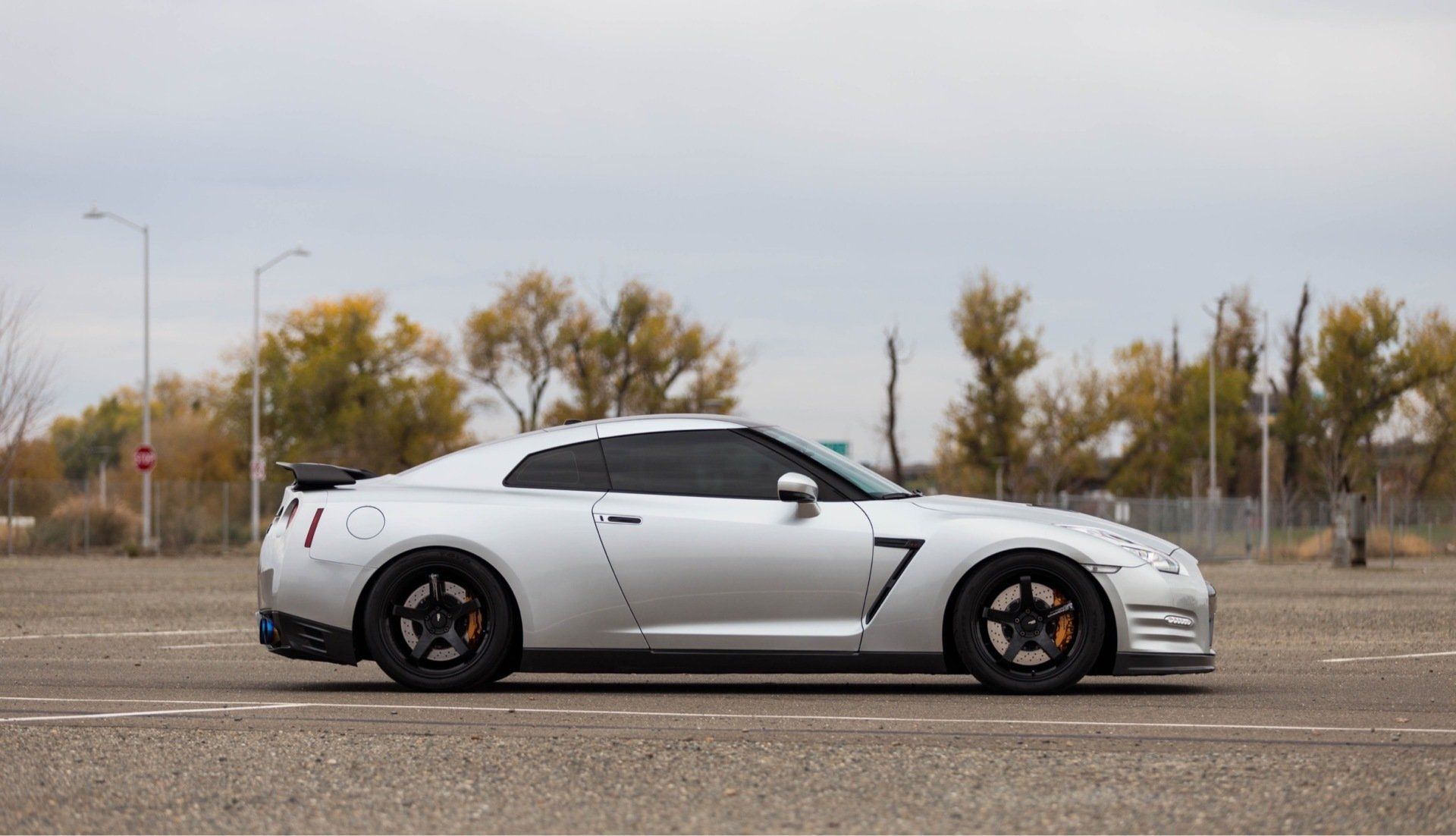 A silver sports car is parked on the side of the road.