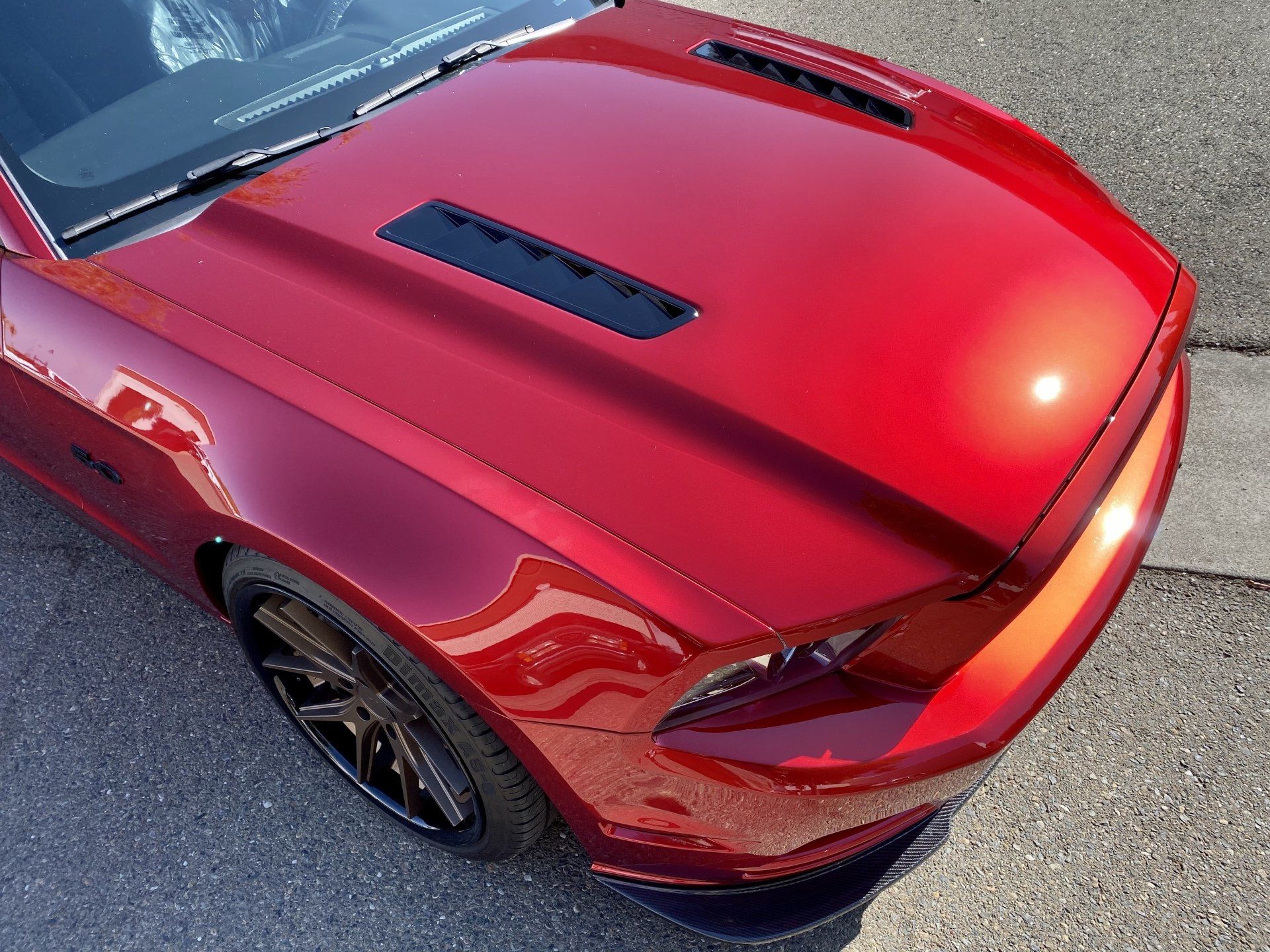 A red car is parked on the side of the road