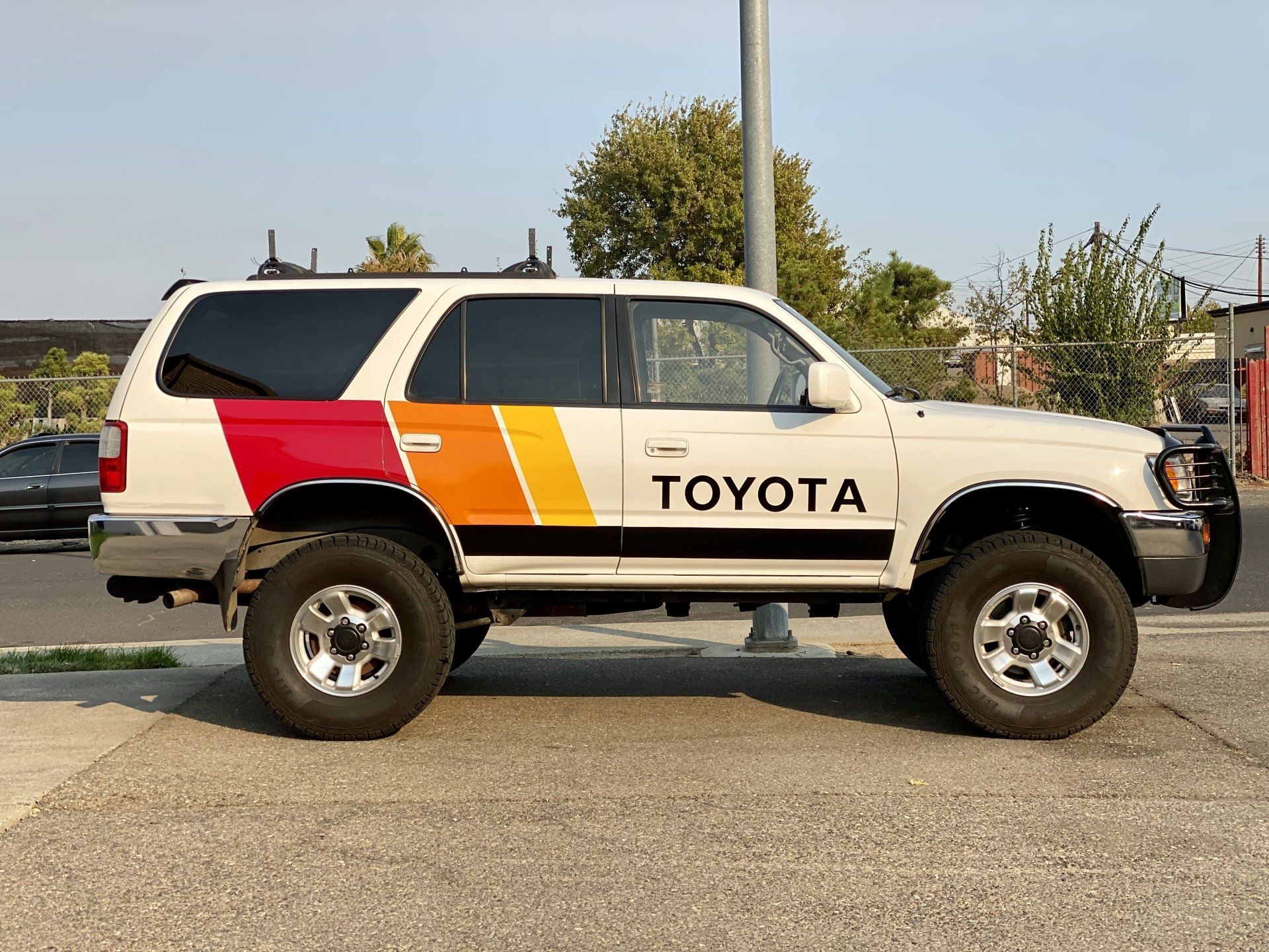 A white toyota suv is parked in a parking lot.