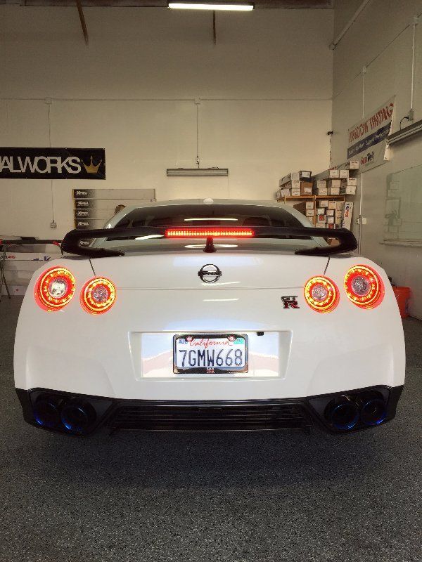 A white nissan sports car is parked in a garage