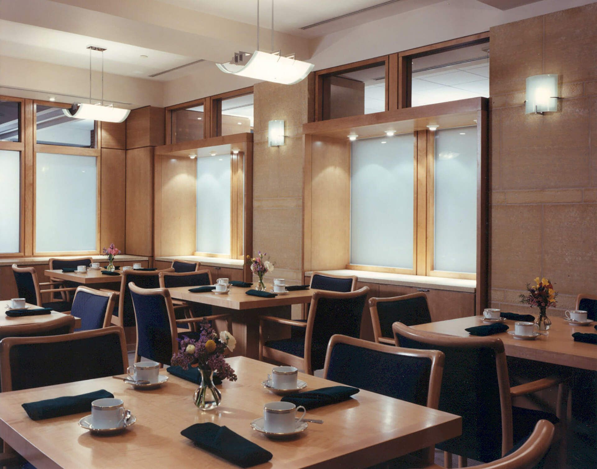 a restaurant filled with tables and chairs with flowers on them