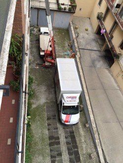 Il camion insieme ad un paniere elevatore effettuando il trasloco Il camion insieme ad un paniere elevatore effettuando il trasloco