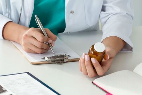 medico mentre scrive una prescrizione