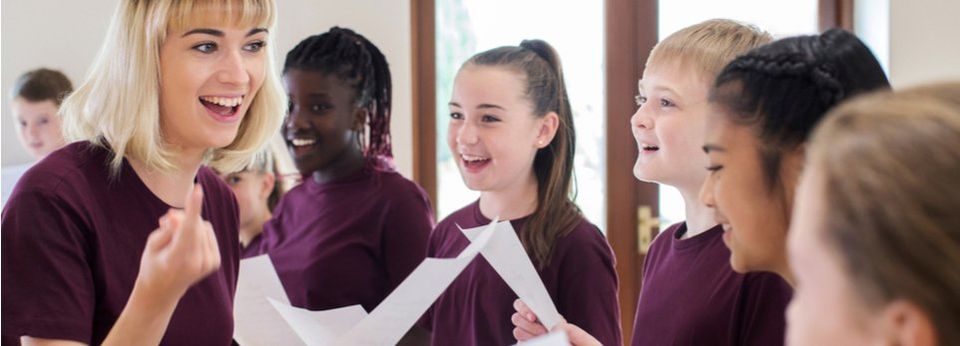 Lehrer hilft Kindern beim Singen