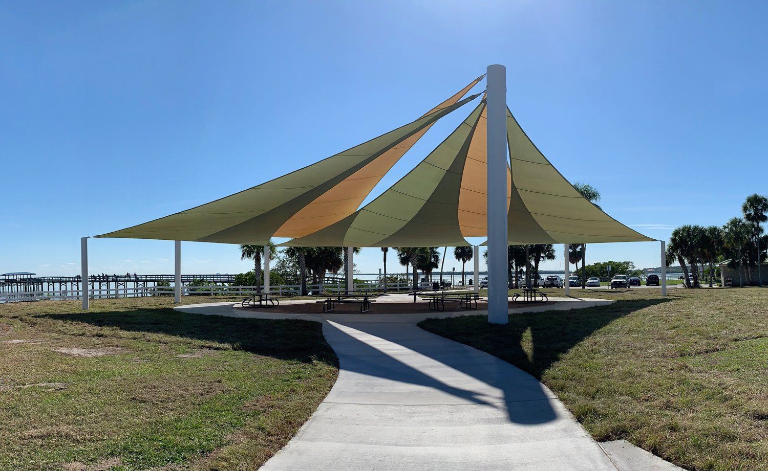 A large umbrella is sitting in the middle of a grassy field.