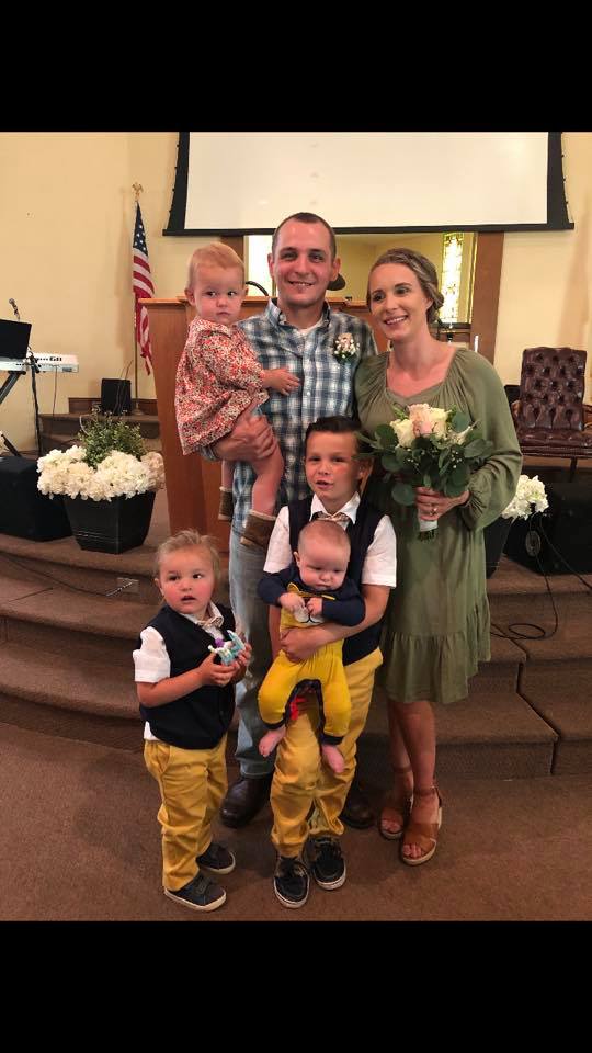 A family is posing for a picture in a church.