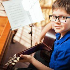 boy learning a guitar course