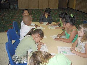 Group of Children coloring with crayons at table — Children's Center in Lakewood,, CA