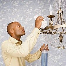 Man Wiping Chandelier - Butlers in Washington, PA Man Wiping Chandelier - Butlers in Washington, PA