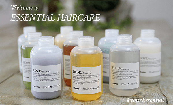 Bottles of essential haircare are lined up on a table