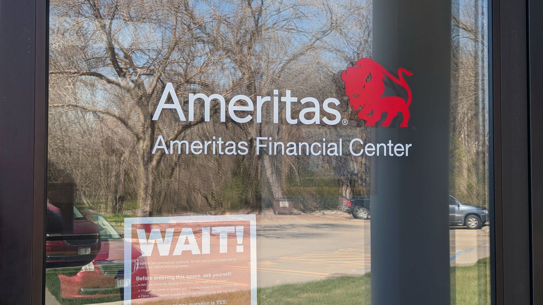 The front door of ameritas ameritas financial center with a sign that says wait.