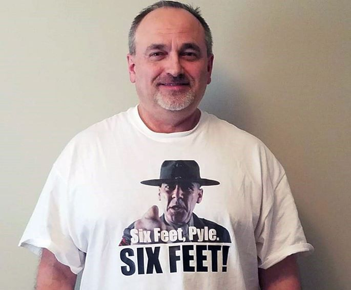 A man wearing a t-shirt that says six feet pyle six feet