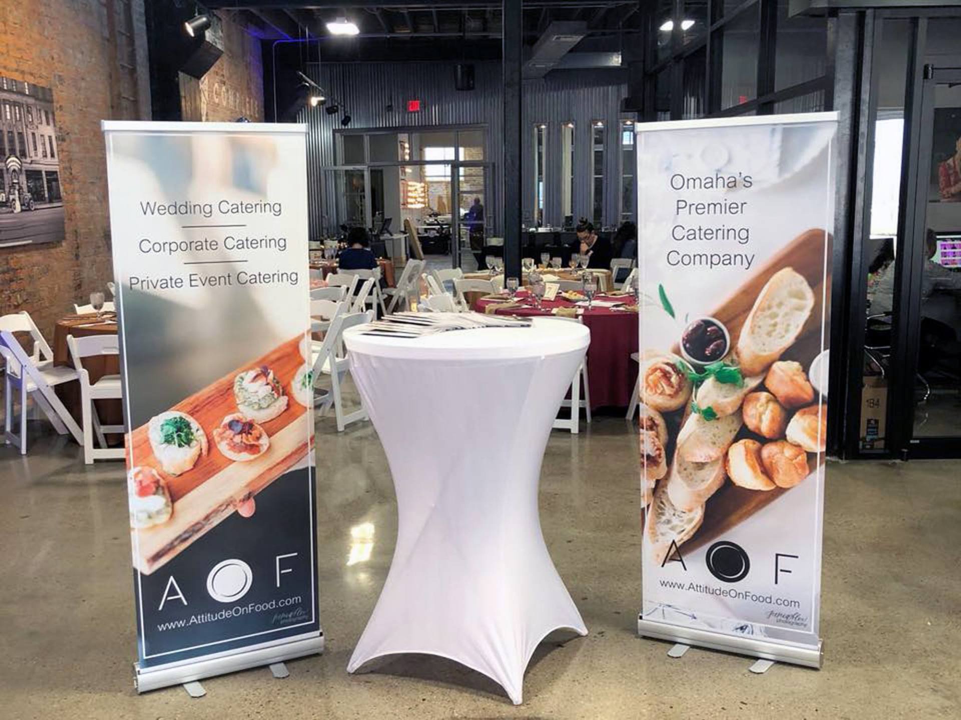 Two banners are sitting next to each other in a room with tables and chairs.
