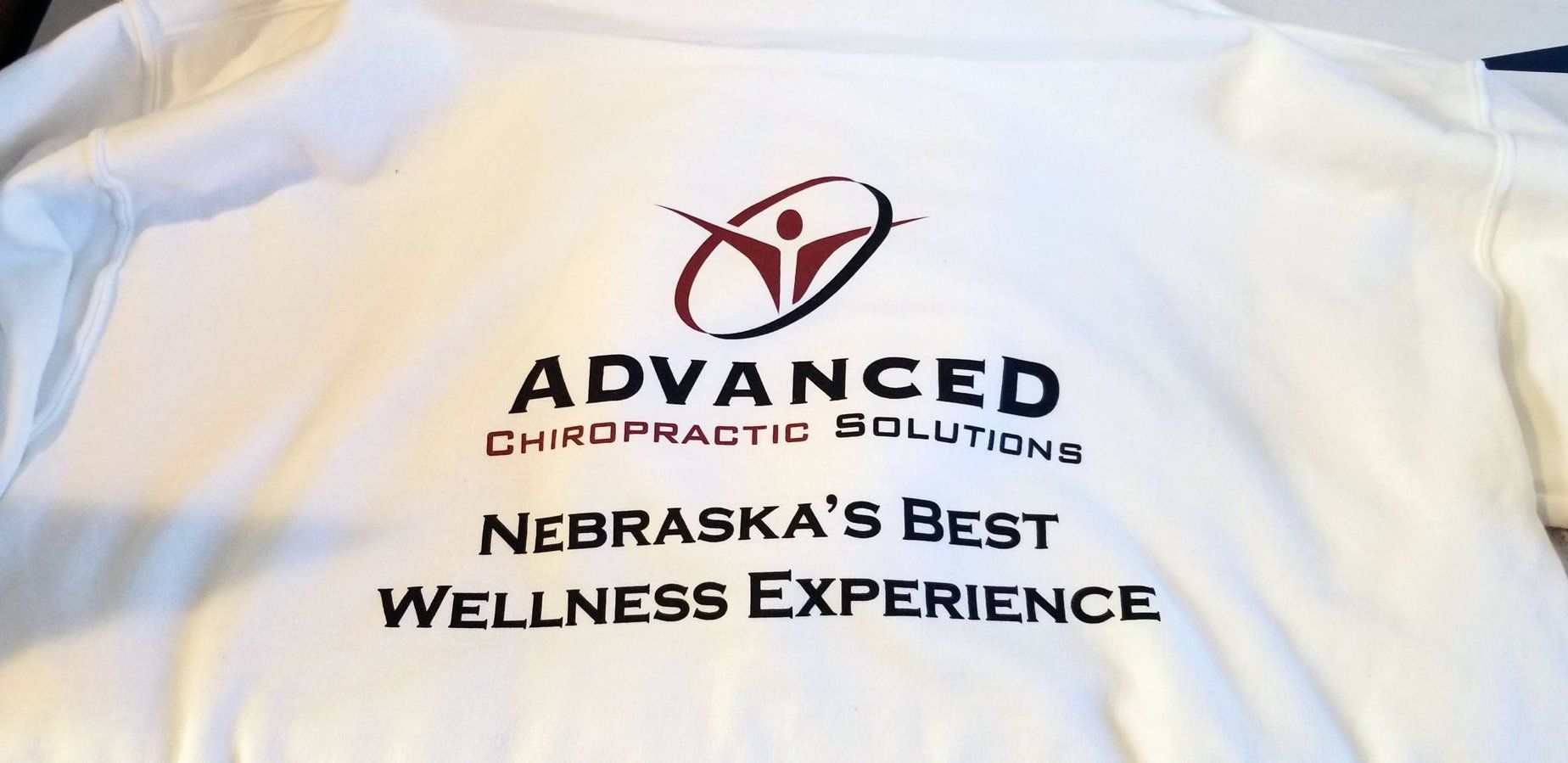 A white shirt that says advanced chiropractic solutions on it