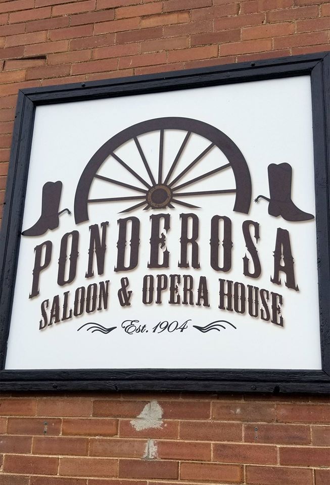 A sign for ponderosa saloon and opera house