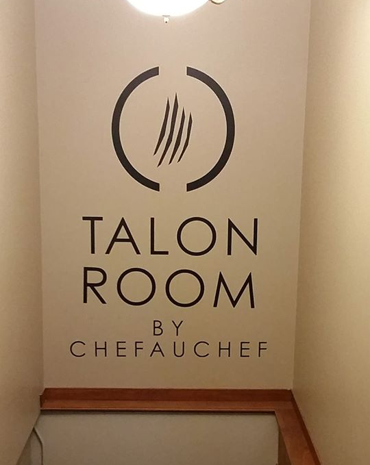 A sign on a wall that says talon room by chef a chef