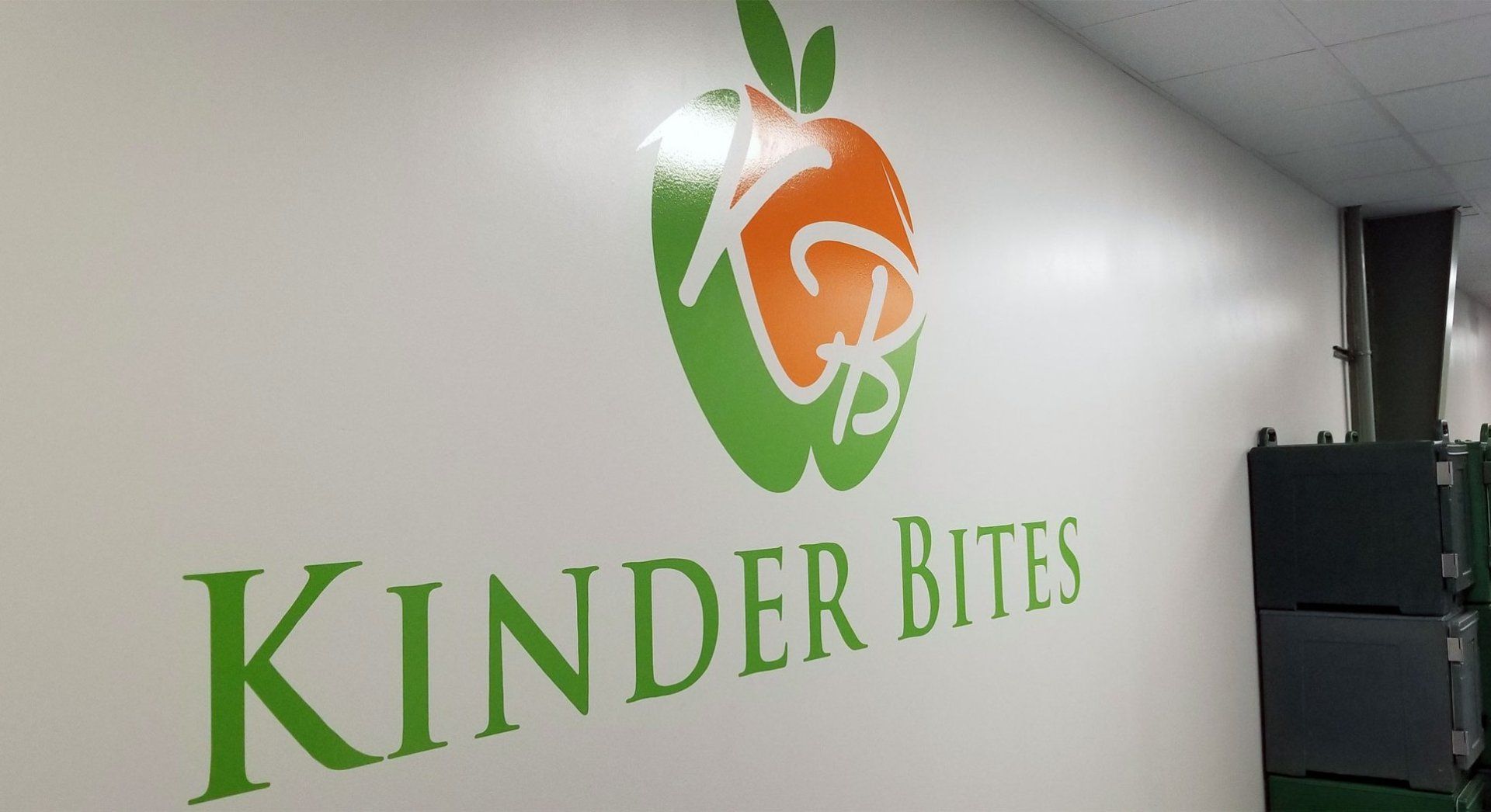 A white wall with a kinder bites logo on it