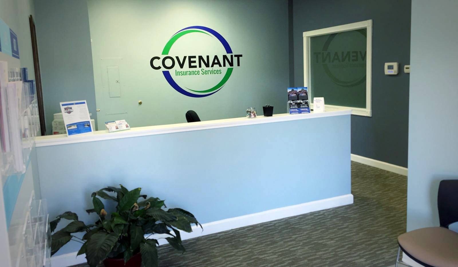 A reception area with a covenant logo on the wall.