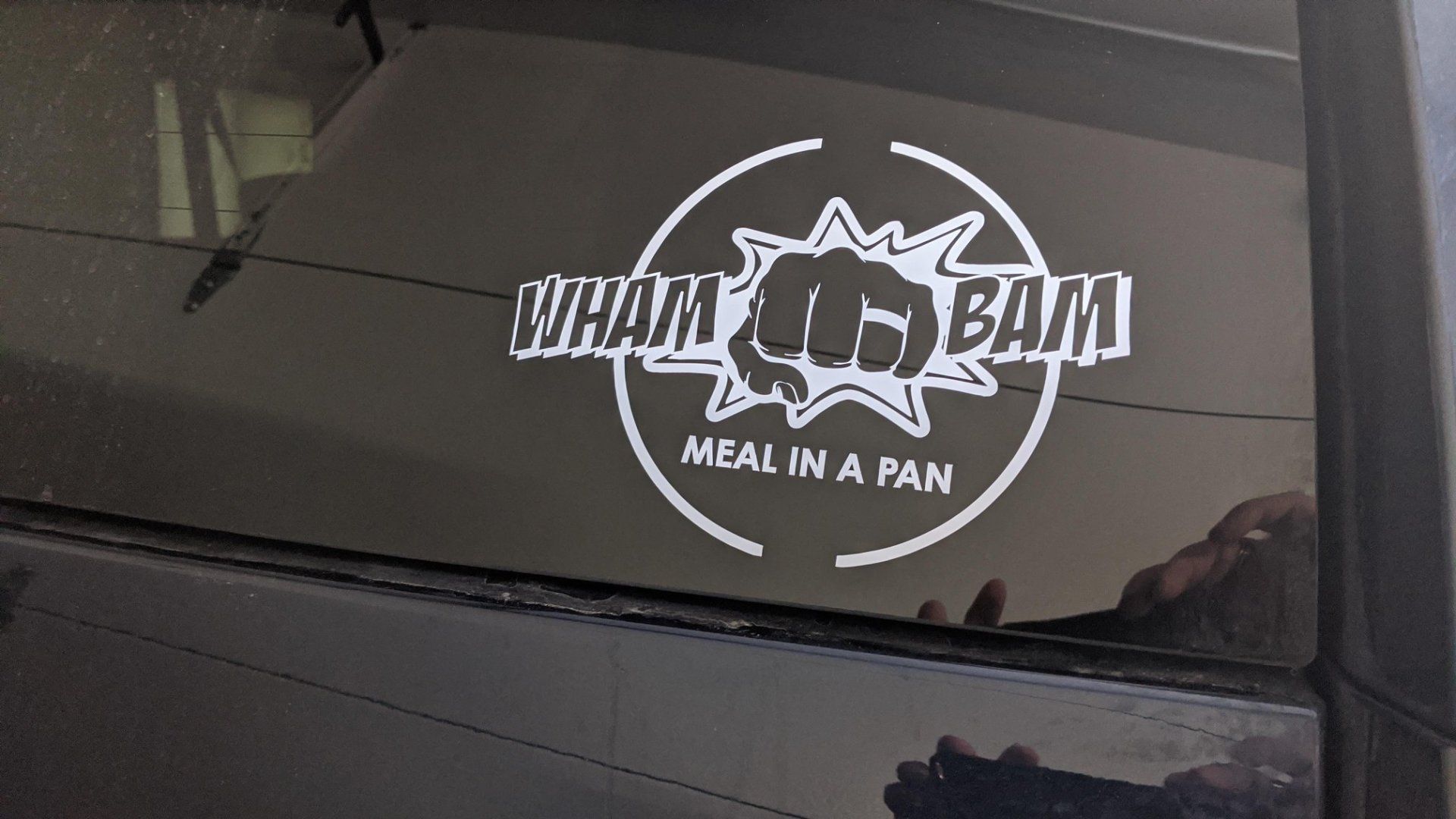 A sticker on a car window that says wham bam meal in a pan