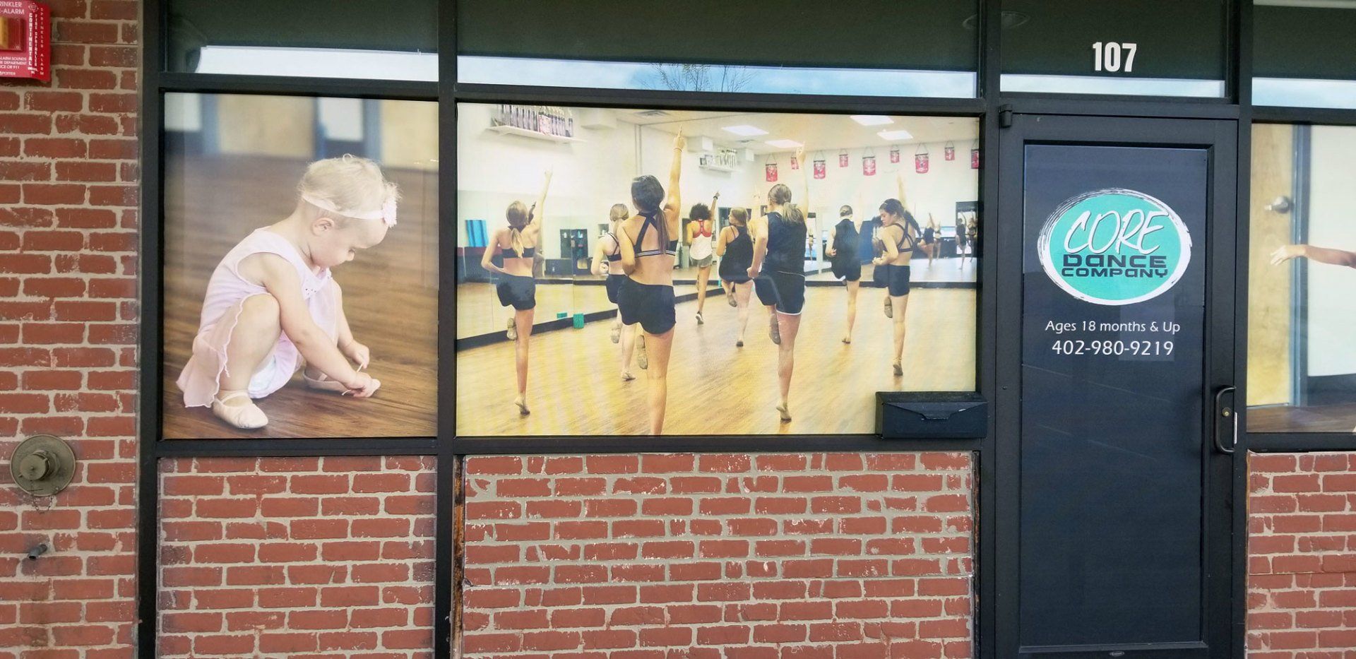 A brick building with a picture of a child in the window.