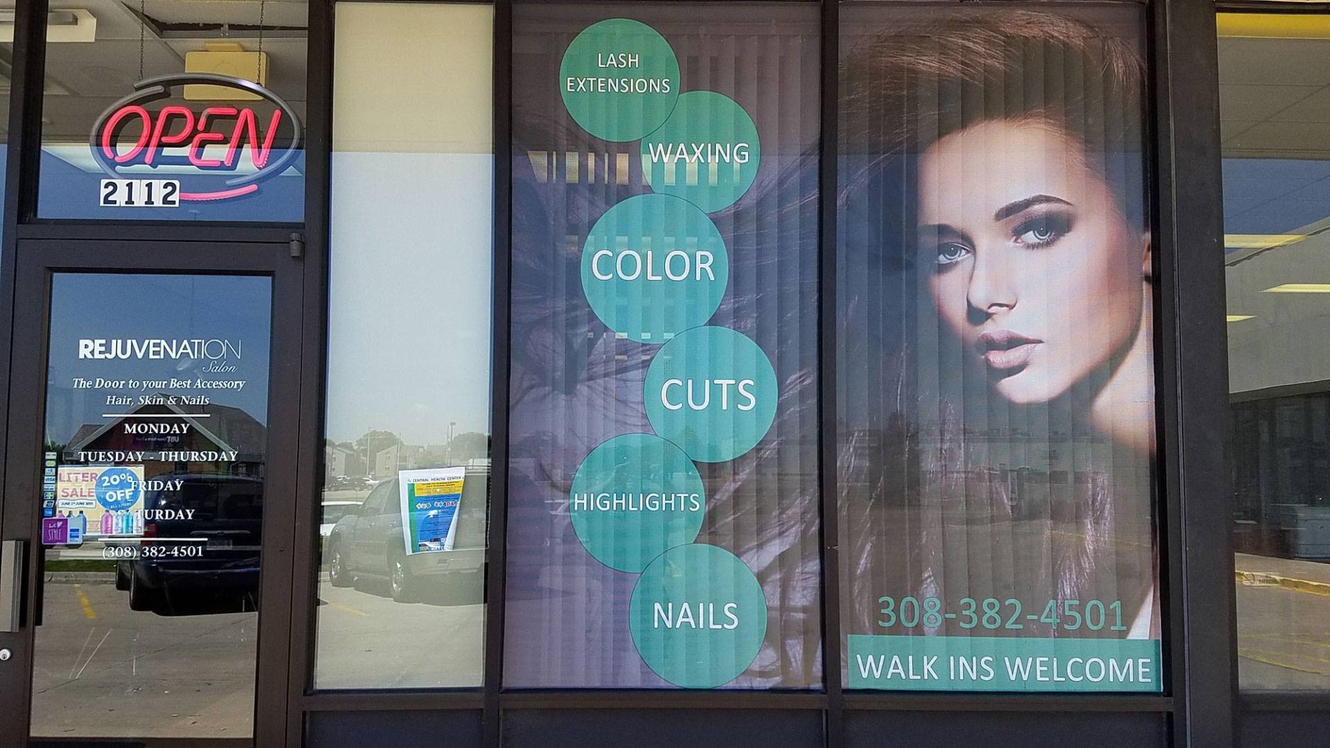A window with a picture of a woman and a sign that says open