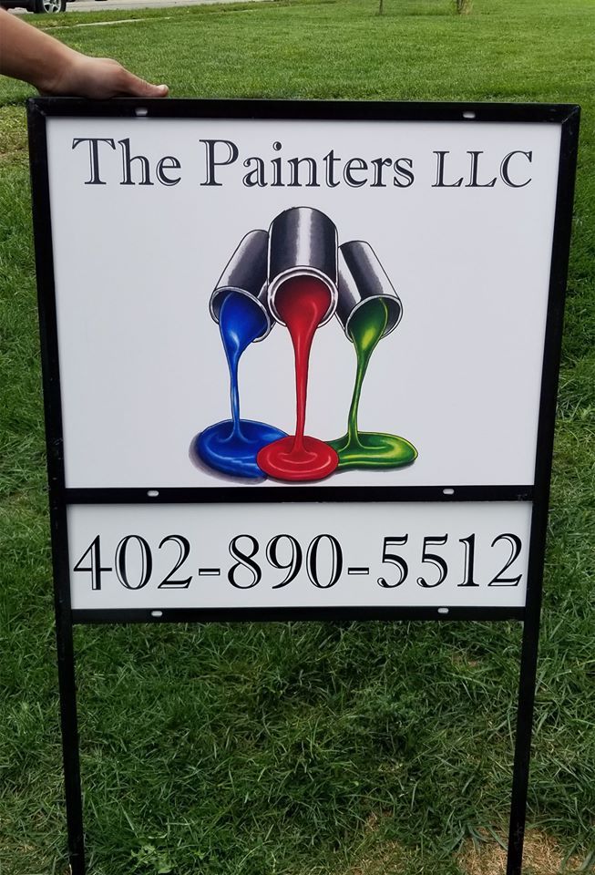 A person is holding a sign for the painters llc