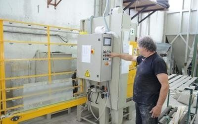 Operaio che presenta la macchina per lavorazione del vetro artistico