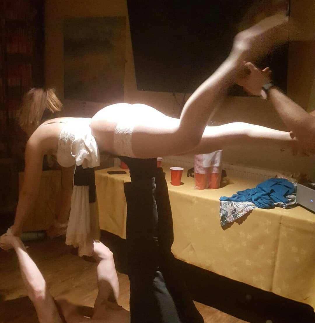 French maid performing acro balance with a stag