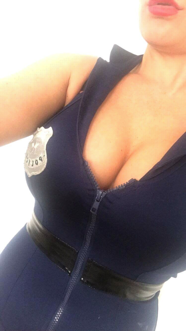 Close-up image of a female stripper in London wearing a police-style costume during a private party performance.