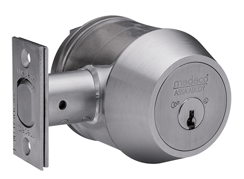 A Medeco Assa Abloy high-security door lock, stainless steel, cylindrical, showing the bolt and keyhole.