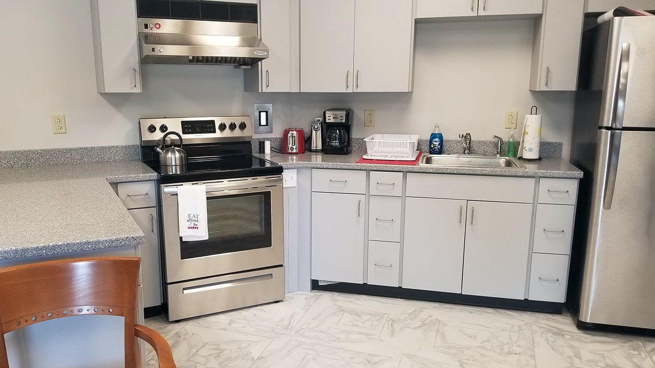 A kitchen with stainless steel appliances and white cabinets