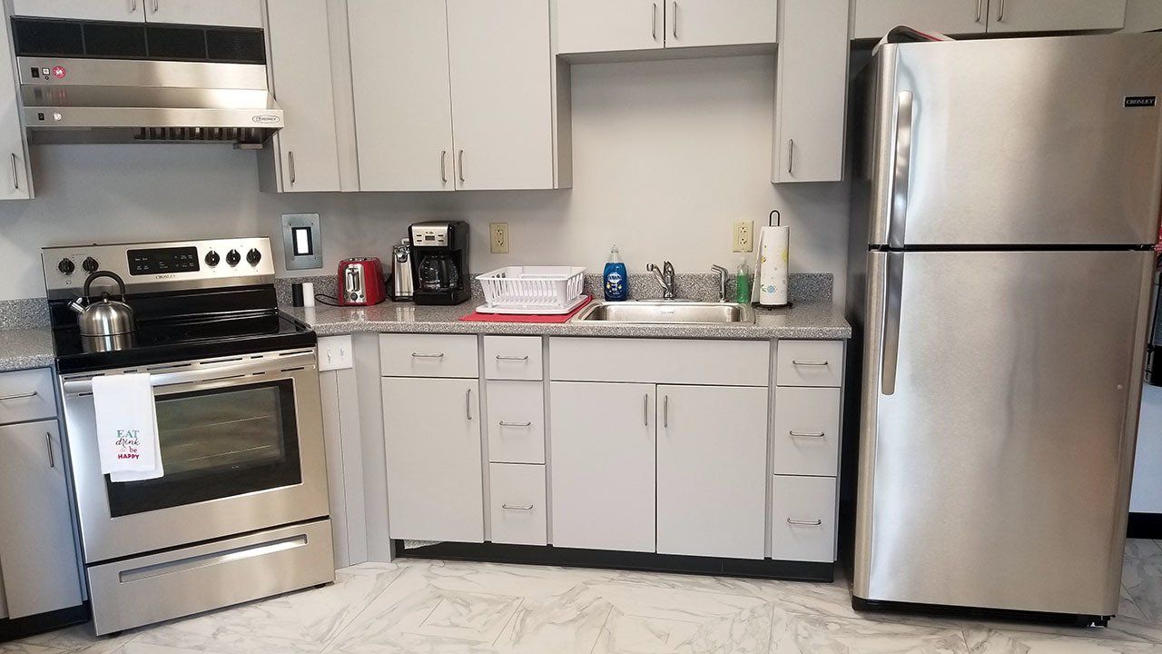A kitchen with stainless steel appliances and white cabinets