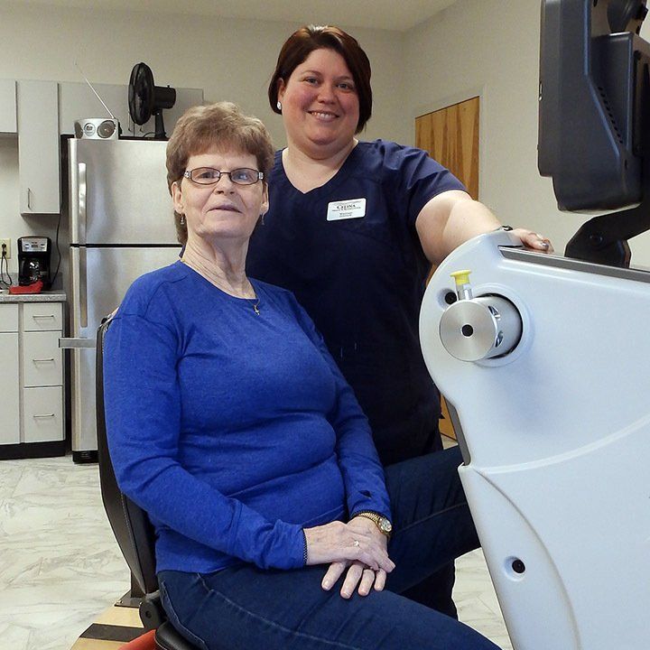 A woman in a blue shirt is sitting next to another woman