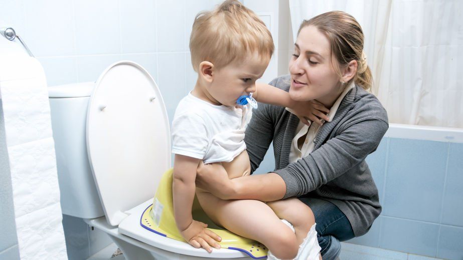 Woman helping her song use a potty chair