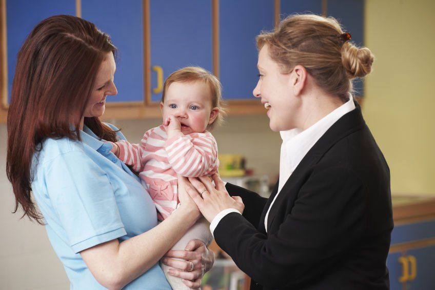 Two women smiling at a baby