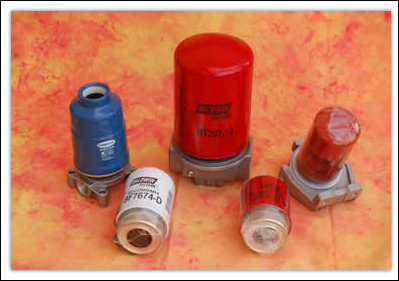Cinco bidones metálicos industriales de color rojo, azul y blanco sobre un fondo naranja.